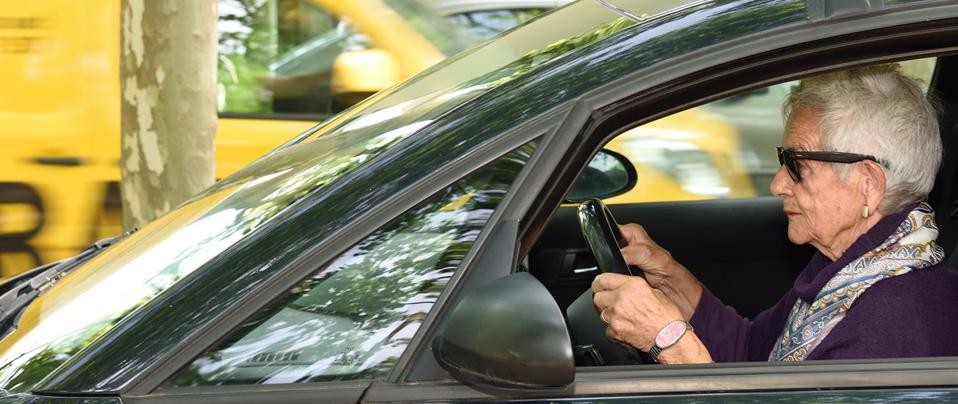 An older woman at the wheel of a car.