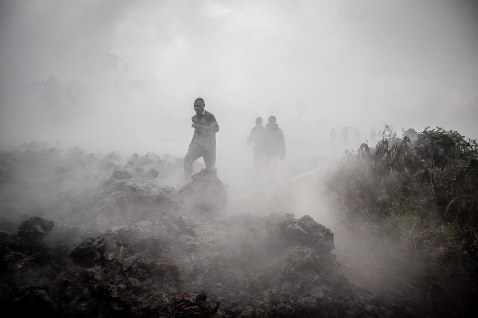 People cross cooled flows of lava near the city of Goma.