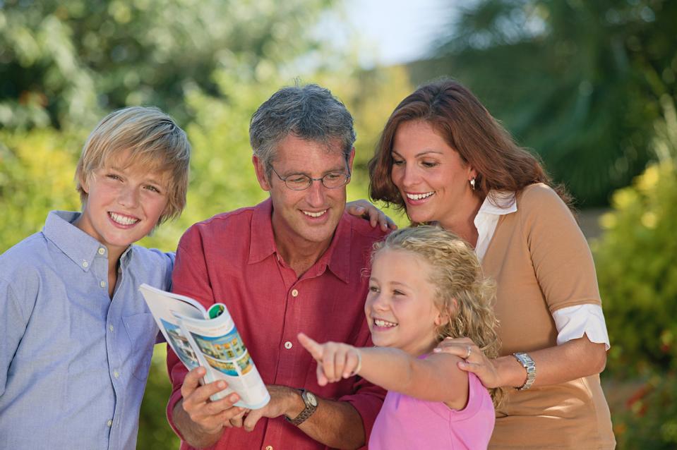 Family looking at guidebook and pointing