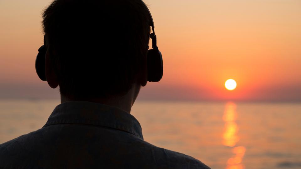 man on beach with headphones