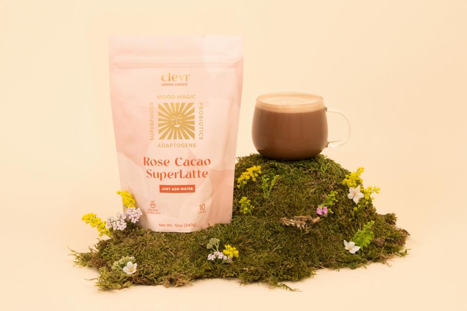 A cup of Clevr Rose Cacao Superlatte on a patch of grass.