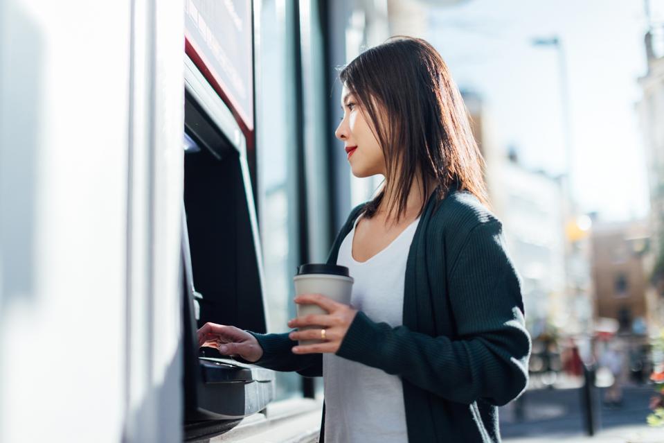 Young Woman Withdrawing Cash Money At The ATM
