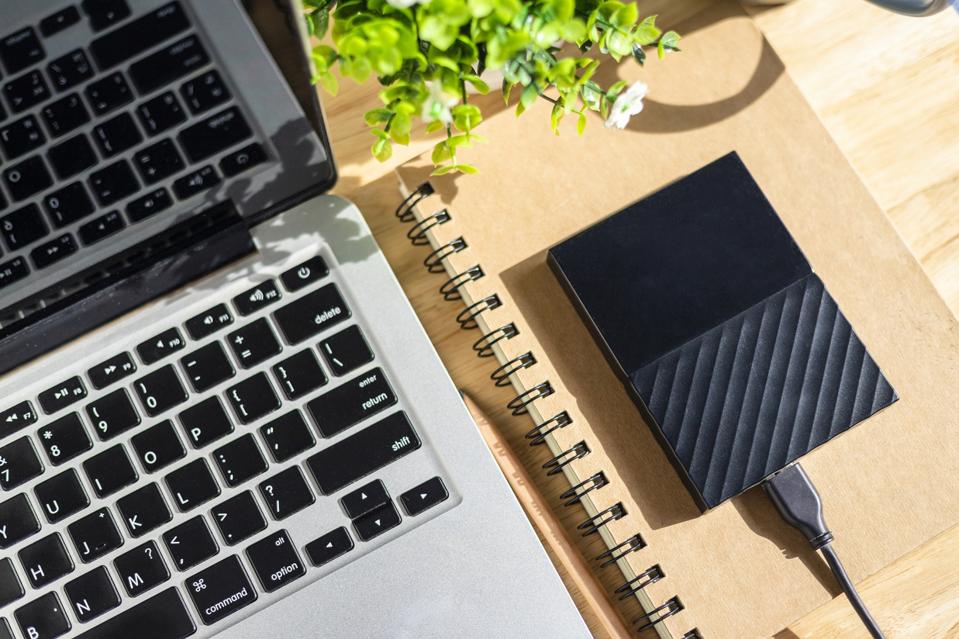 High Angle View Of Laptop With Hard Drive On Table