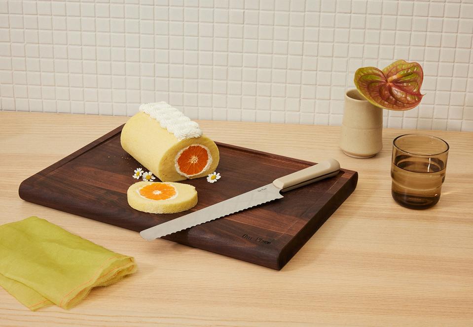 Our Place serrated knife plus walnut cutting board on a kitchen counter