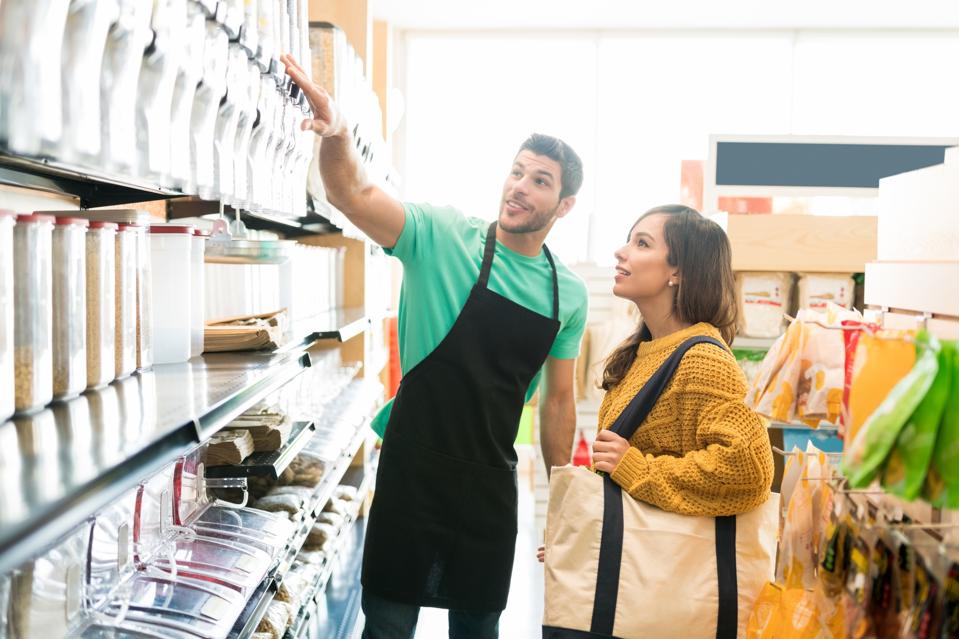 Salesman Assisting Customer In Buying At Store