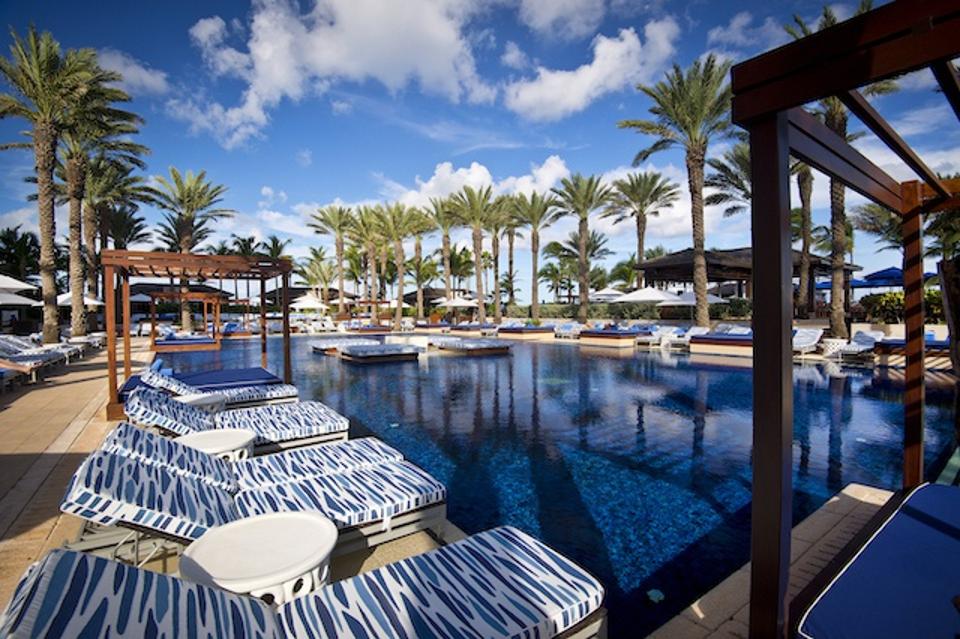a tranquil pool surrounded by lounge chairs and palm trees