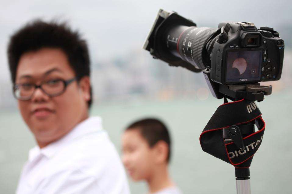 A man looks at a camera displaying a pic