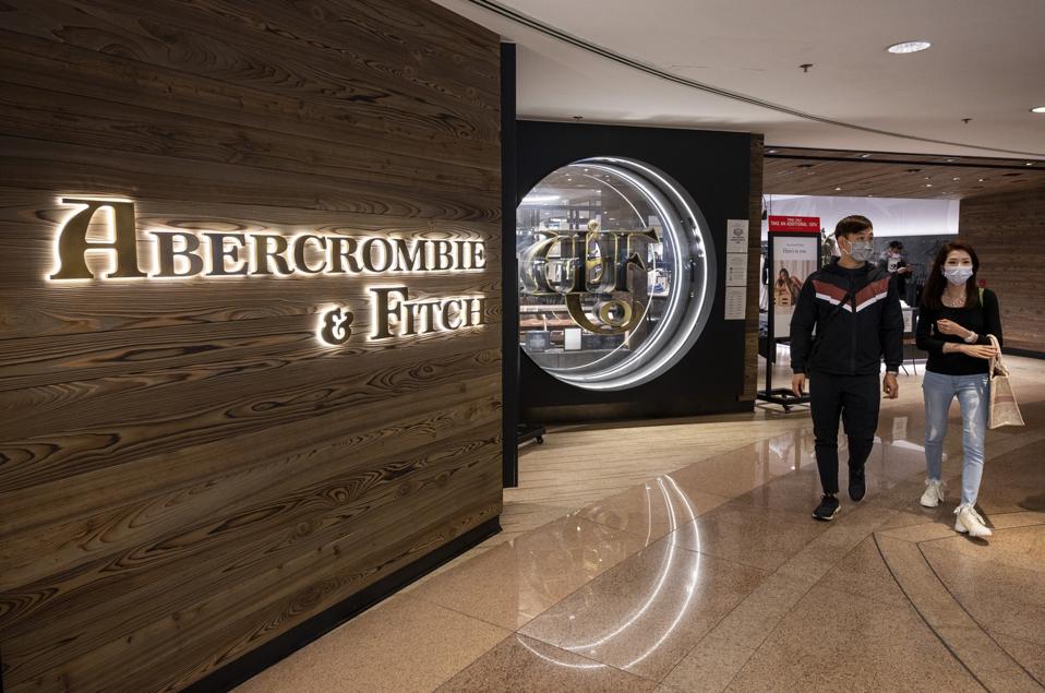 Shoppers walk past the American fashion brand Abercrombie &...
