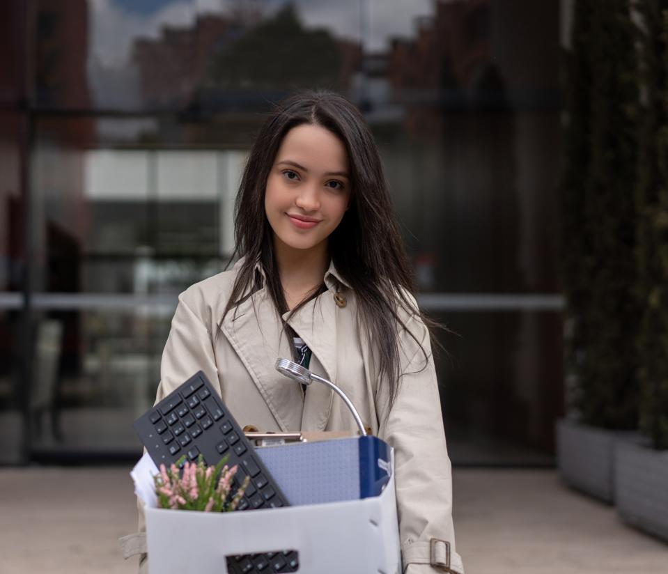 Woman quitting her job and holding her belongings in a box