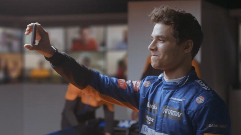 McLaren driver Lando Norris with a smartphone