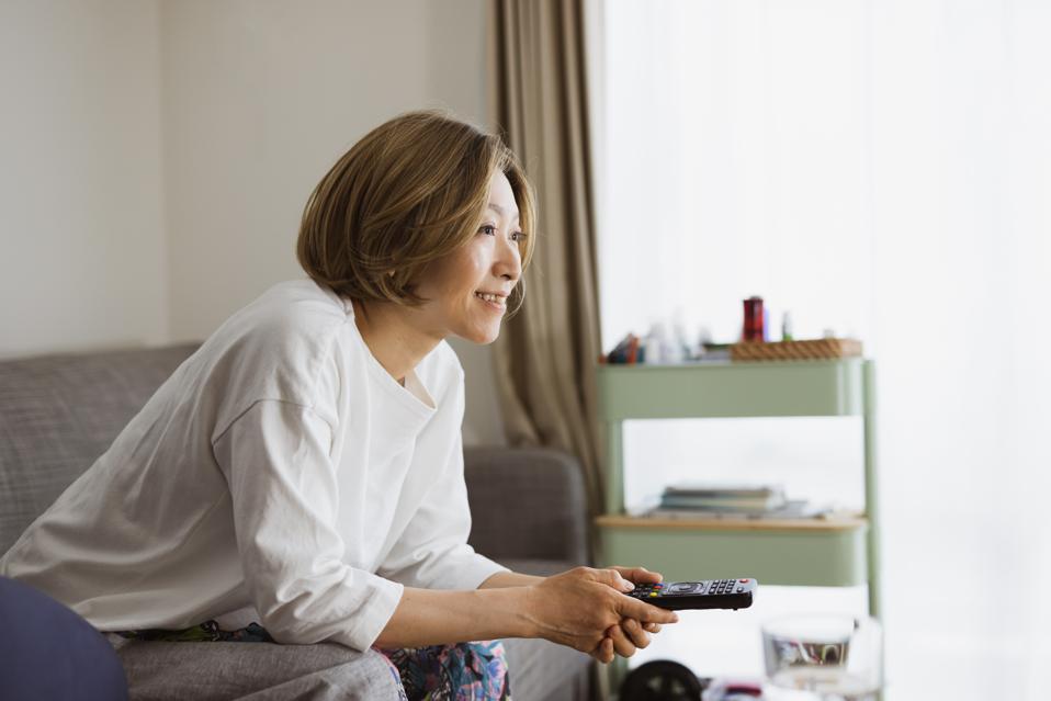 a woman watching tv on sofa