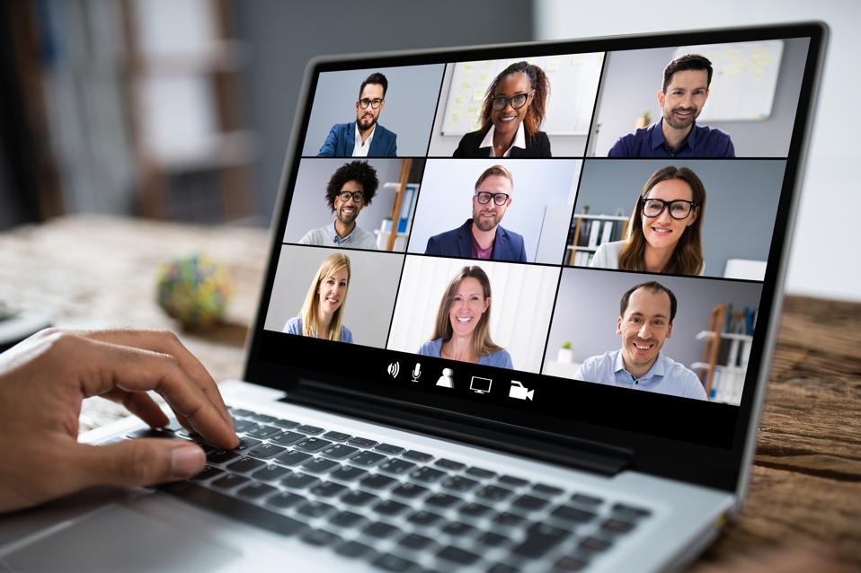 Professionals Using Laptop At Desk In Office
