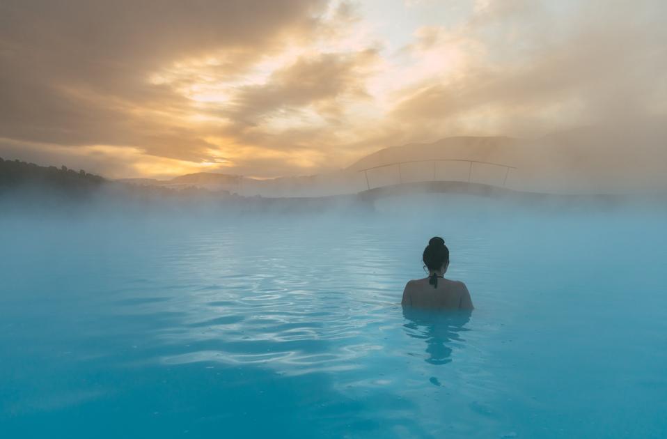 A woman relaxing in the ocean at dawn in Iceland.