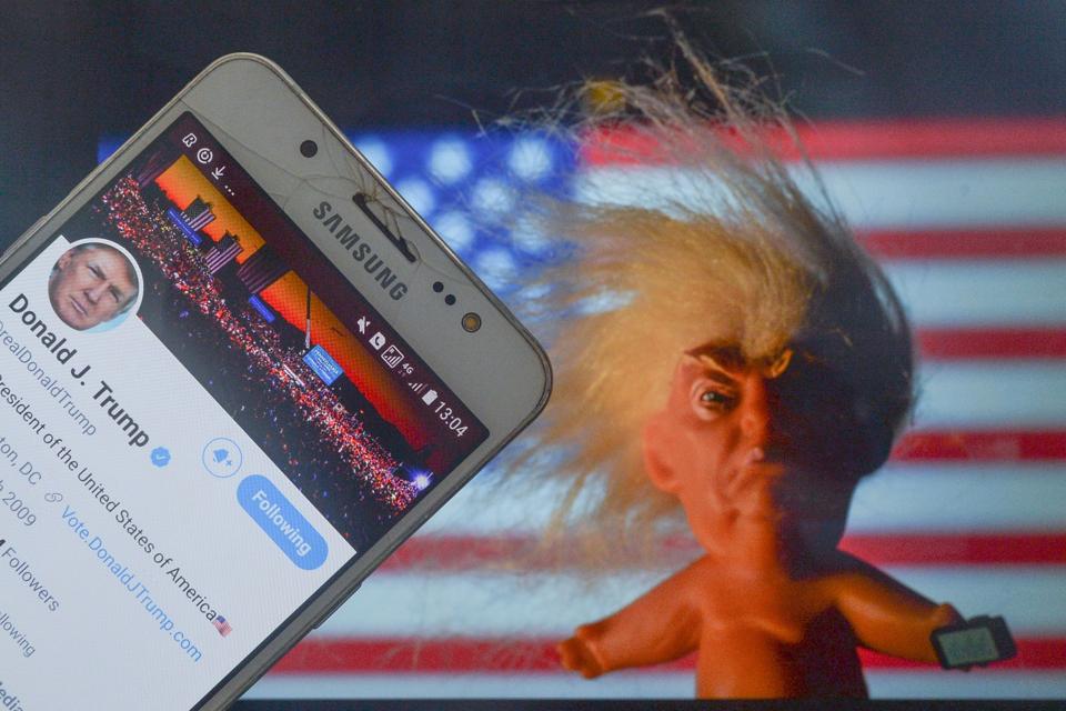 Donald Trump's Twitter account displayed on a mobile phone screen next to a vinyl doll which features the U.S. President Donald Trump, seen in front of the U.S. flag. On Saturday, 9 January 2021, in Dublin, Ireland. (Photo by Artur Widak/NurPhoto via Getty Images)