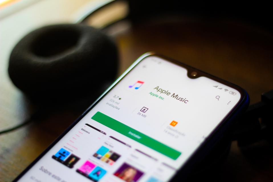 In this photo illustration the Apple Music logo and app is...