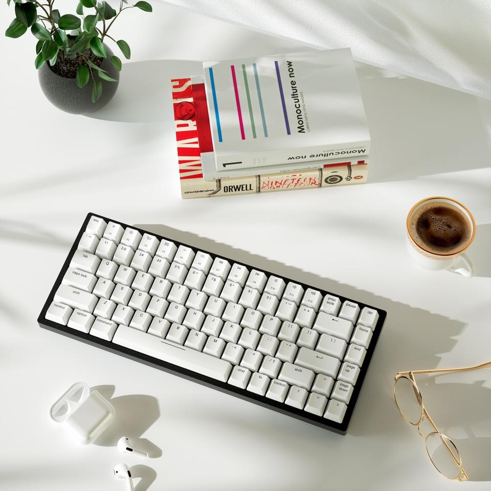 Vissles V84 mechanical keyboard on a table with some books and a cup of coffee