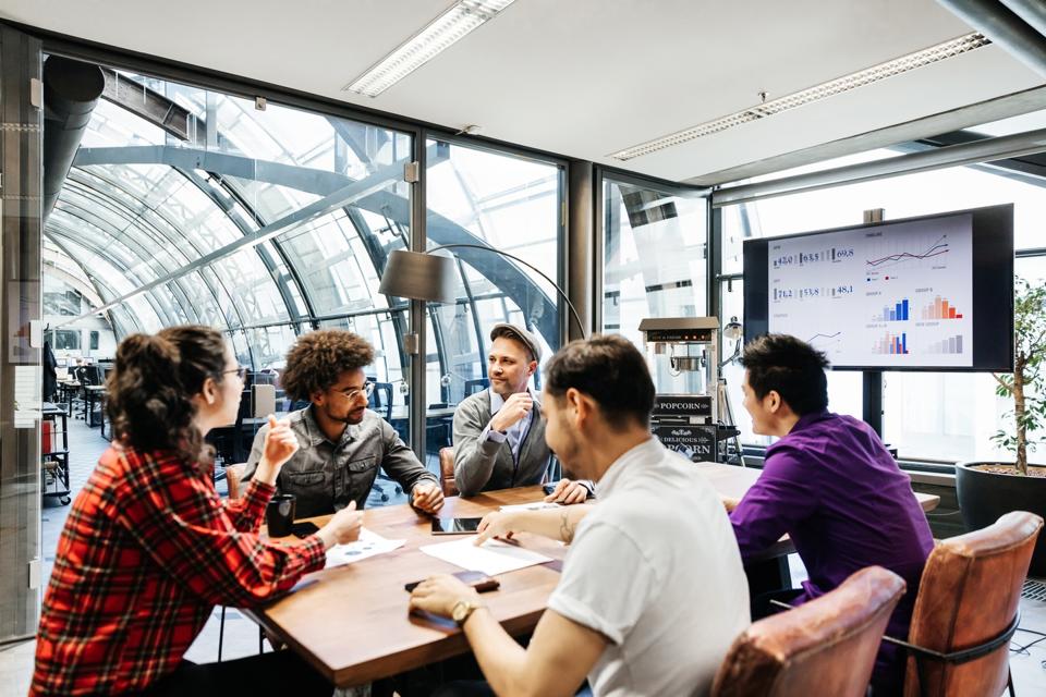 Team Leaders Sitting At Conference Table For Meeting