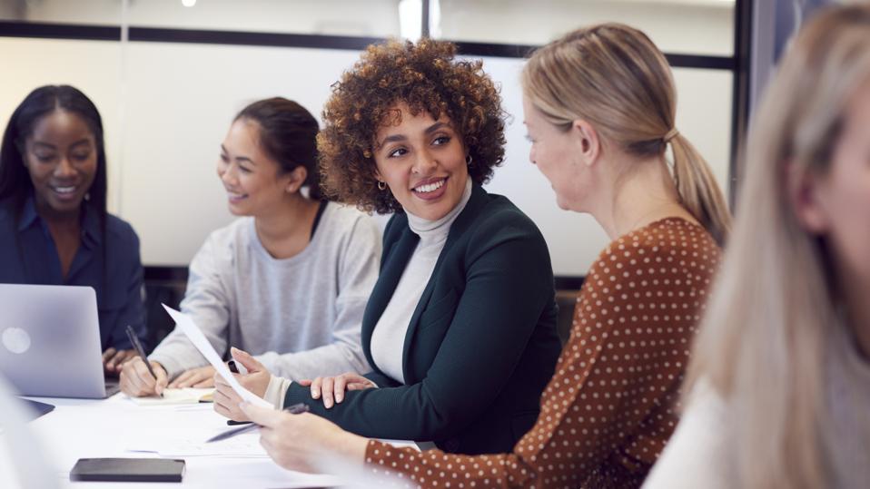 Group Of Businesswomen Collaborating In Creative Meeting Around Table In Modern Office