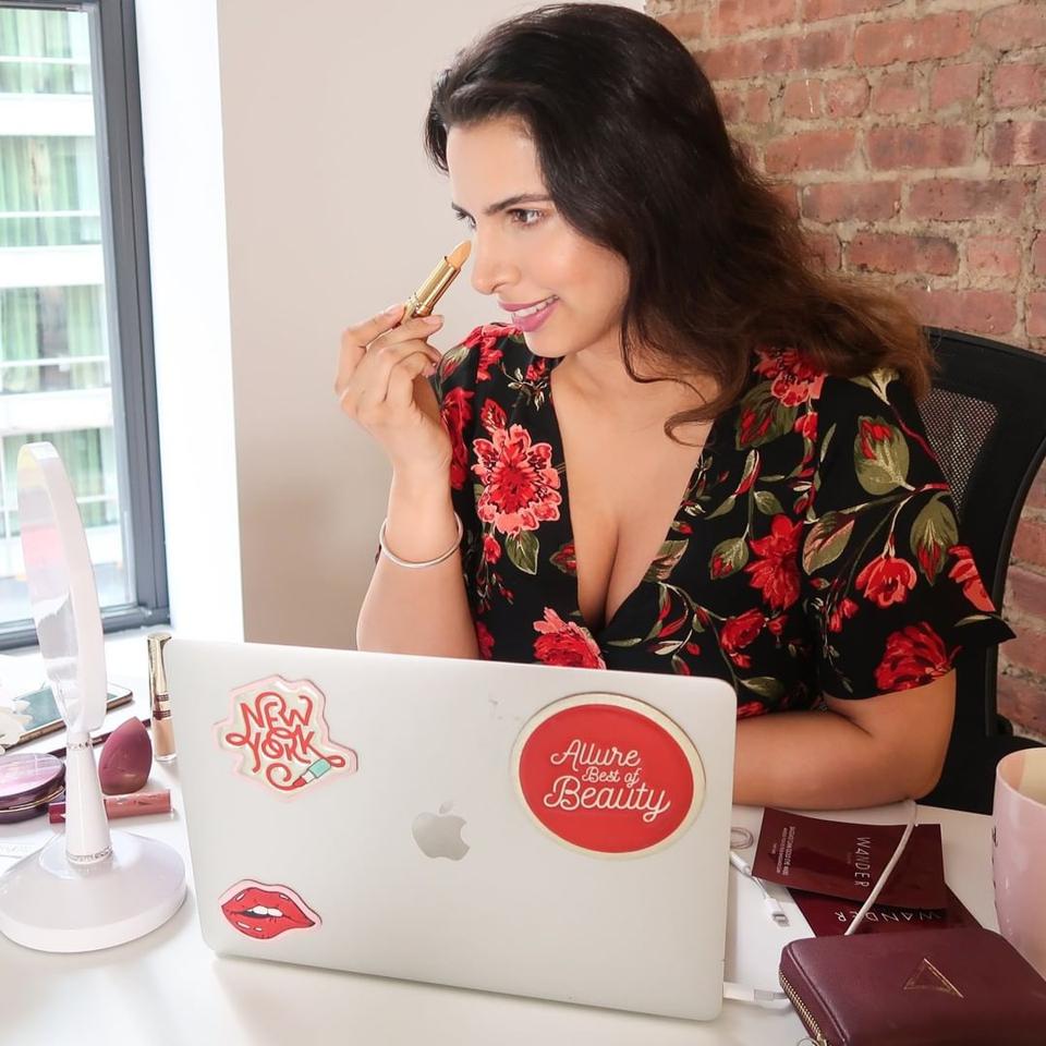 Divya Gugnani applies makeup at her desk