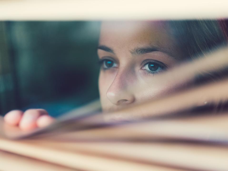 Unhappy woman looking through the window