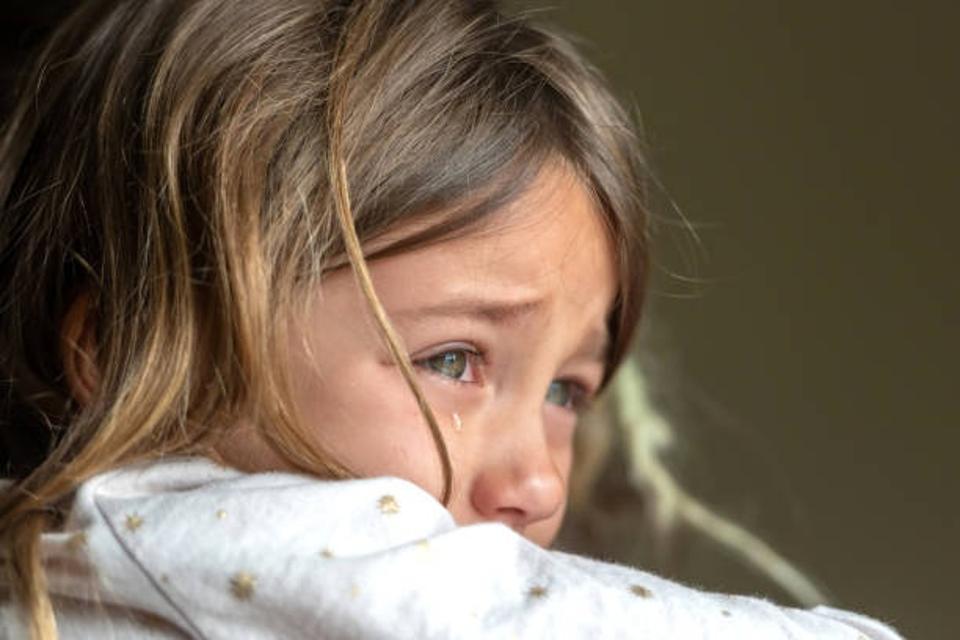 A young girl cries and grieves the loss of a parent.