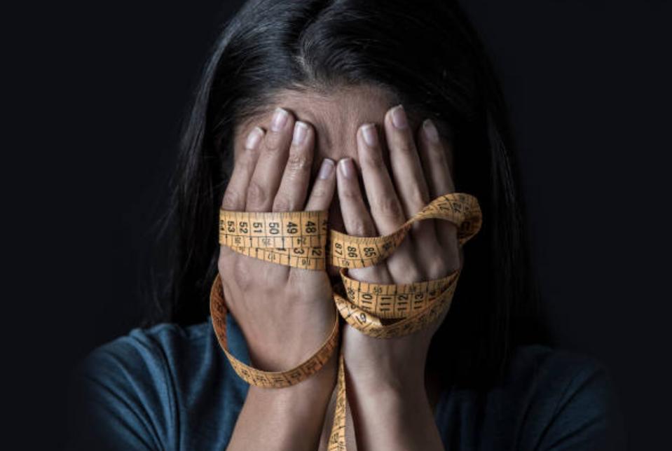 girl with head in hands and tape measure