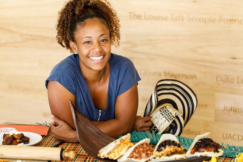 Headshot of Isis Arrieta-Dennis wiht platter of arepas.