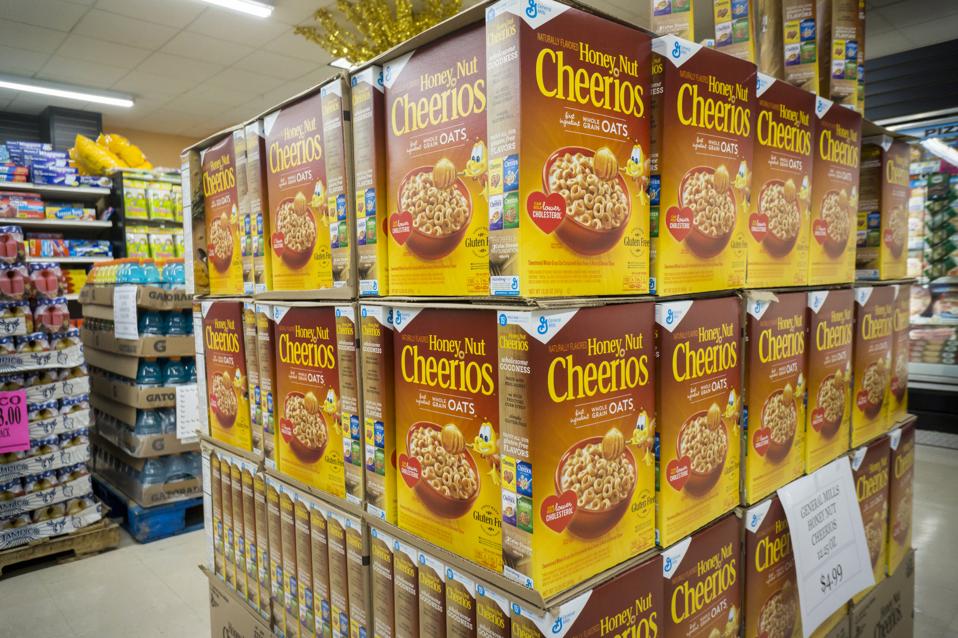 A display of boxes of General Mills Honey Nut Cheerios cereal in a supermarket.
