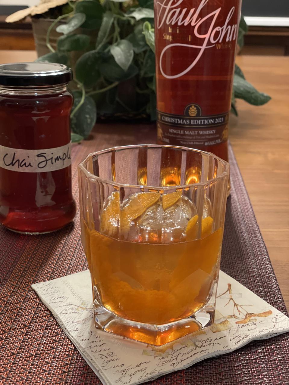 Chai Tea Old-Fashioned with Paul John Indian Single Malt Whisky bottle and housemate Chai Simple Syrup in a jar in this photograph by Elizabeth Karmel
