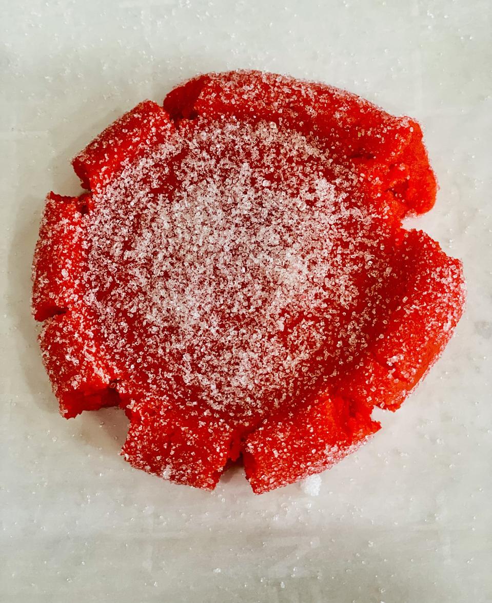 A Red Rolled, Sugared and Flattened Mexican Sugar Cookie is Ready for the Oven in a photo by Elizabeth Karmel