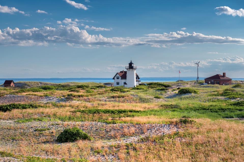 Lighthouse on sand dunes in Cape Cod beach