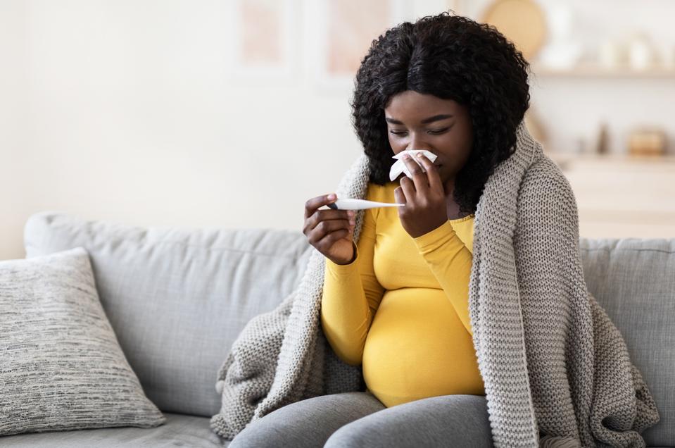 Young pregnant african woman feeling sick with high fever