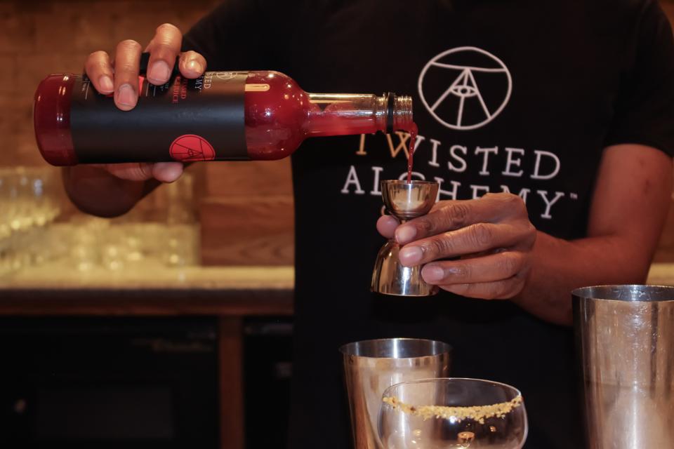Nigal Vann, winner of The Best Black Bartender In America, mixes a cocktail with Twisted Alchemy Blood Orange Juice.