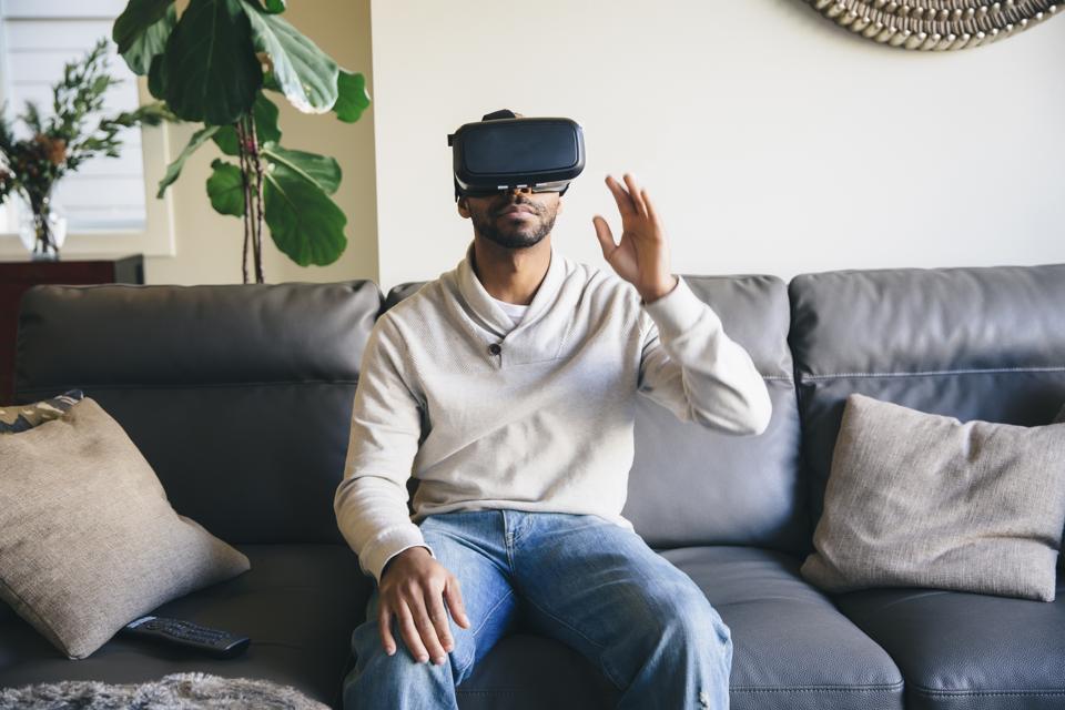 Hombre de raza mixta que usa gafas de realidad virtual