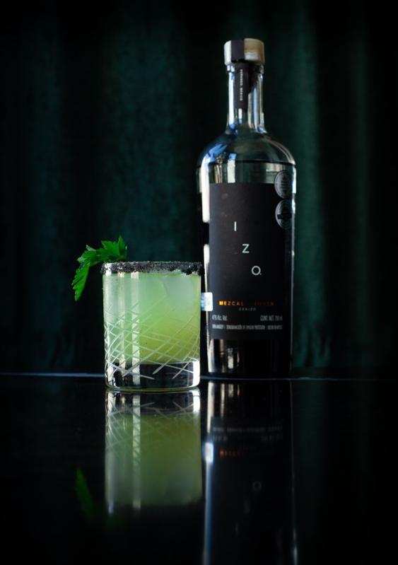 Bottle of IZO Mezcal with cocktail glass