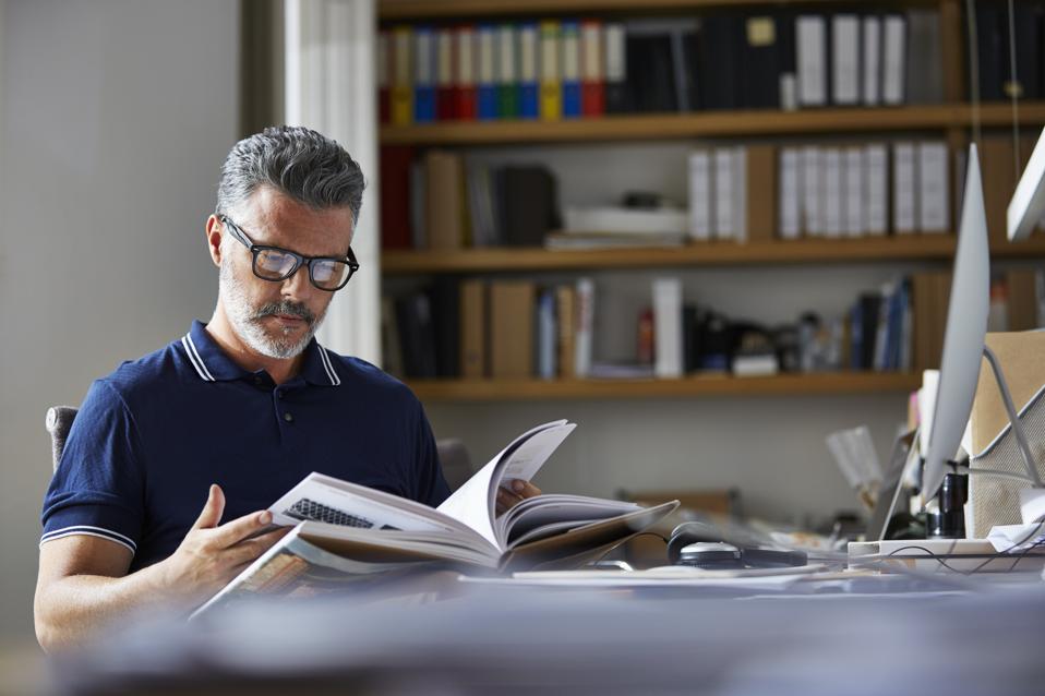 Businessman reading book at desk