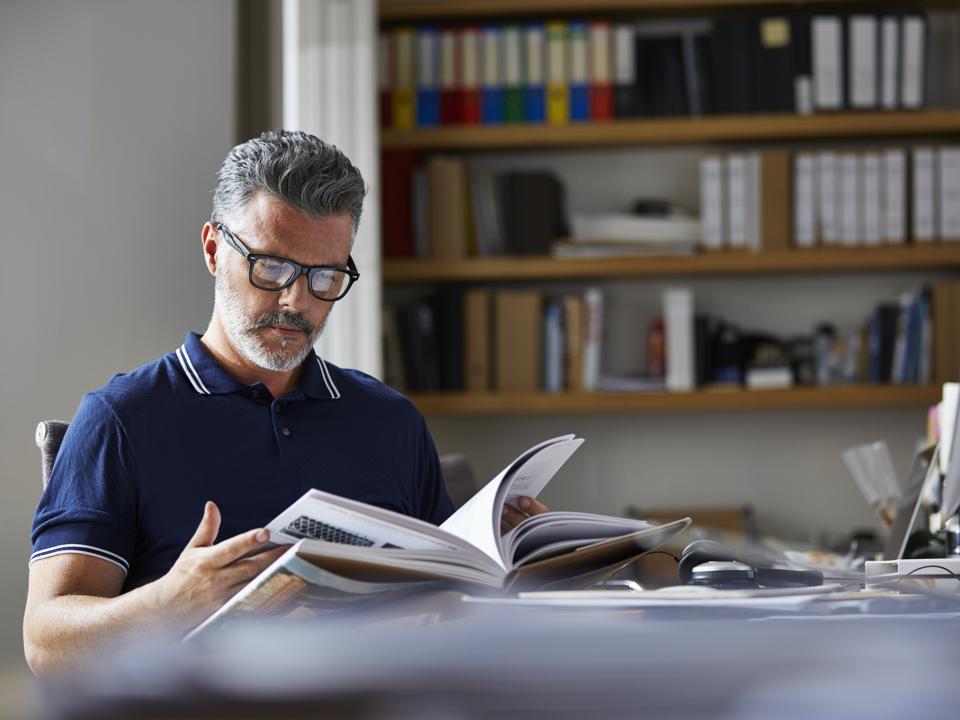 Businessman reading book at desk