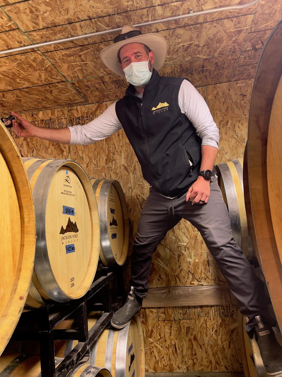 A.J. Puccia, Assistant Winemaker at Jackson Hole Winery extracting wine from a barrel.