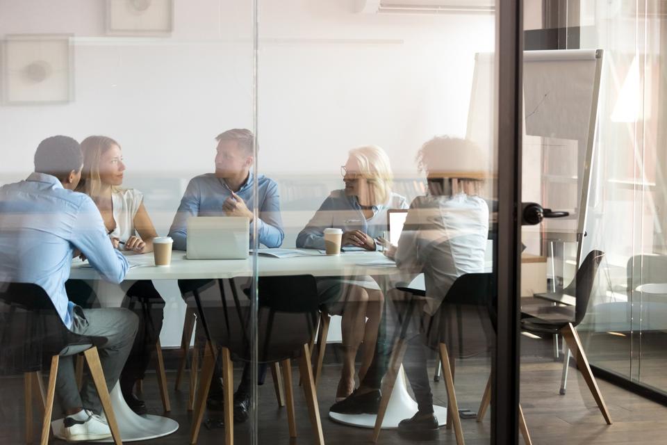 Creative team discussing marketing strategy with clients in a conference room.