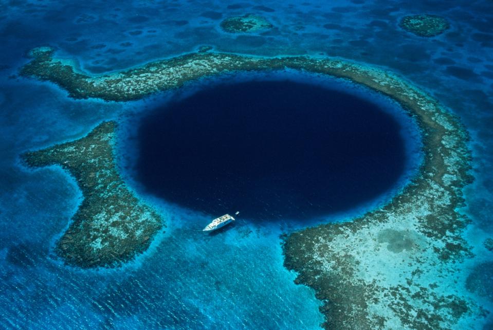 Belize, Lighthouse Reef, boat moored at Blue Hole, aerial view