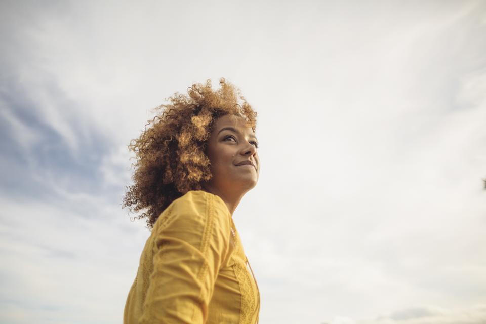 Retrato de mujer hermosa en ángulo bajo contra el cielo