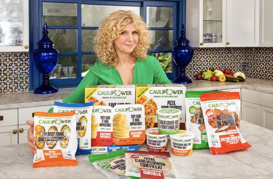Founder and CEO of CAULIPOWER, Gail Becker, with an assortment of CAULIPOWER products.