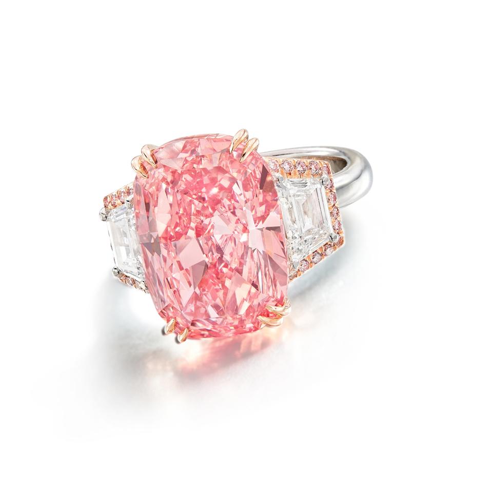 The Williamson Pink Star is mounted in an 18k gold ring flanked by diamonds