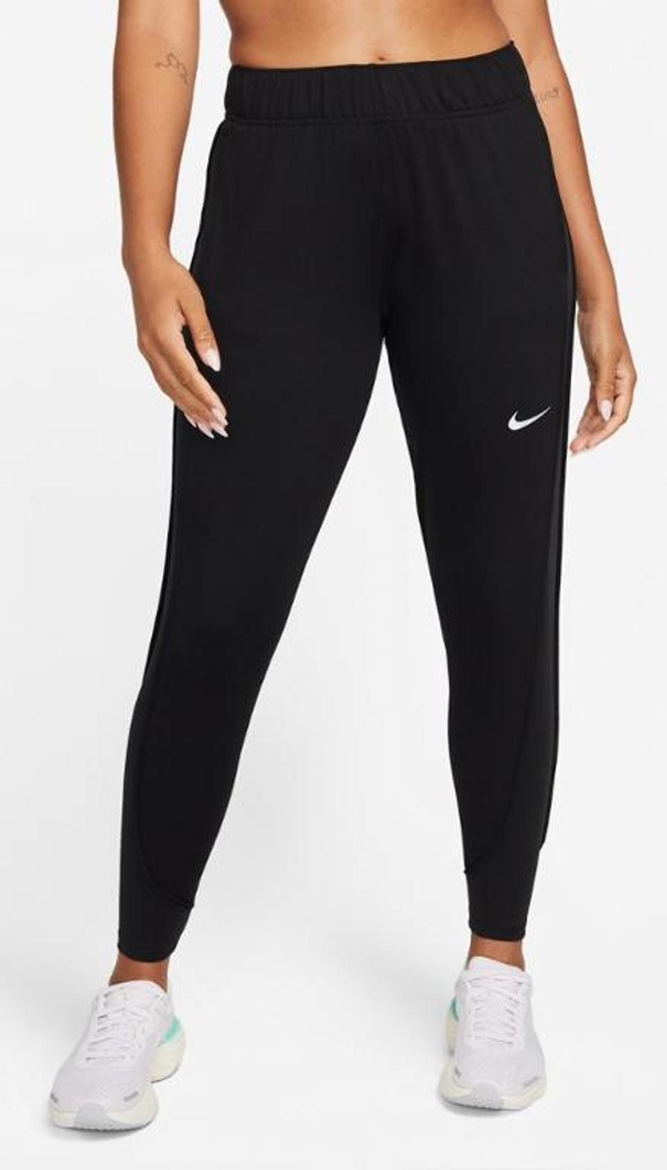 view of a woman's lower half wearing black Nike pants with white swoosh