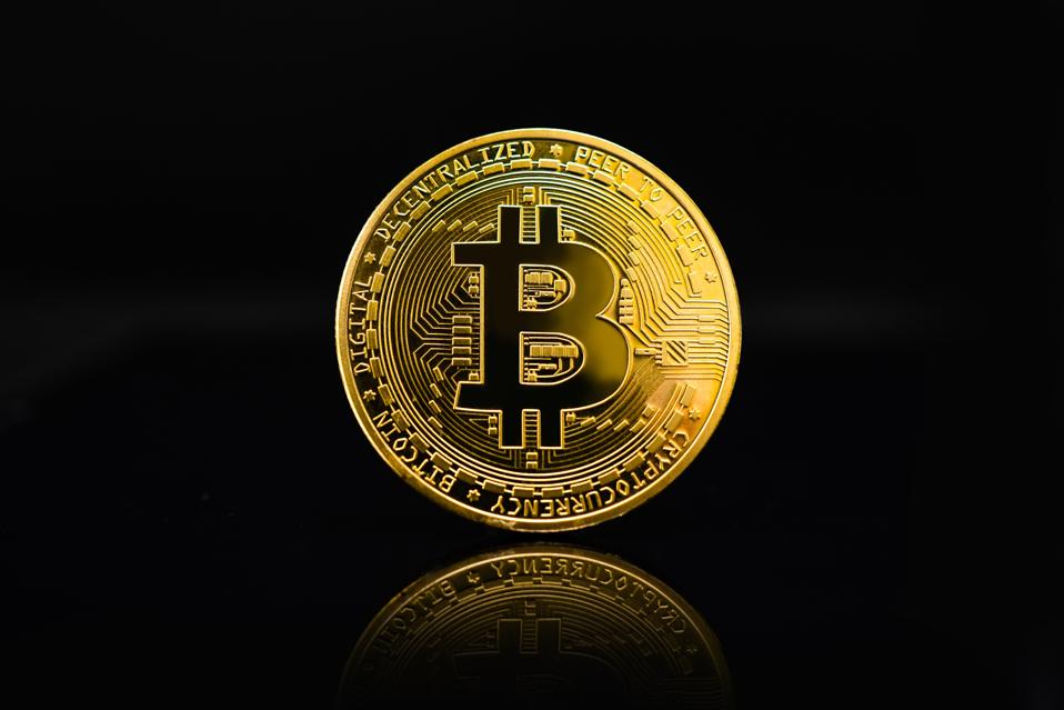 A bitcoin coin on a black background.