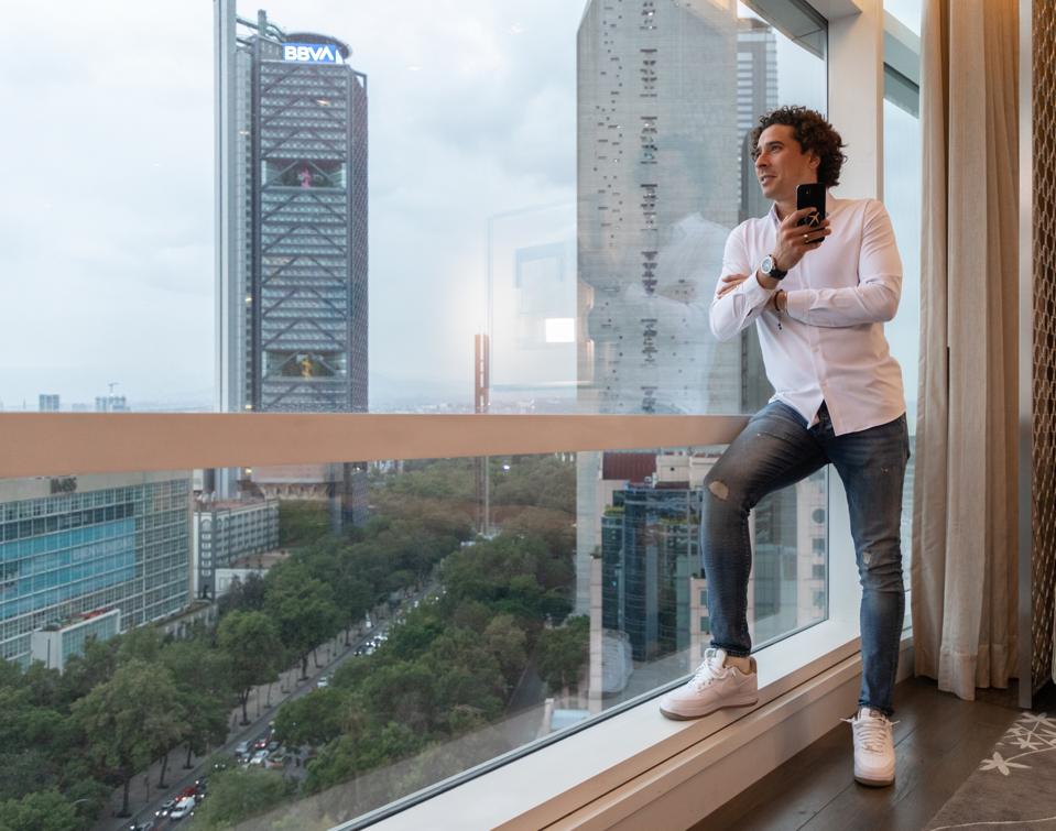 Memo Ochoa looking out a window high above Mexico City