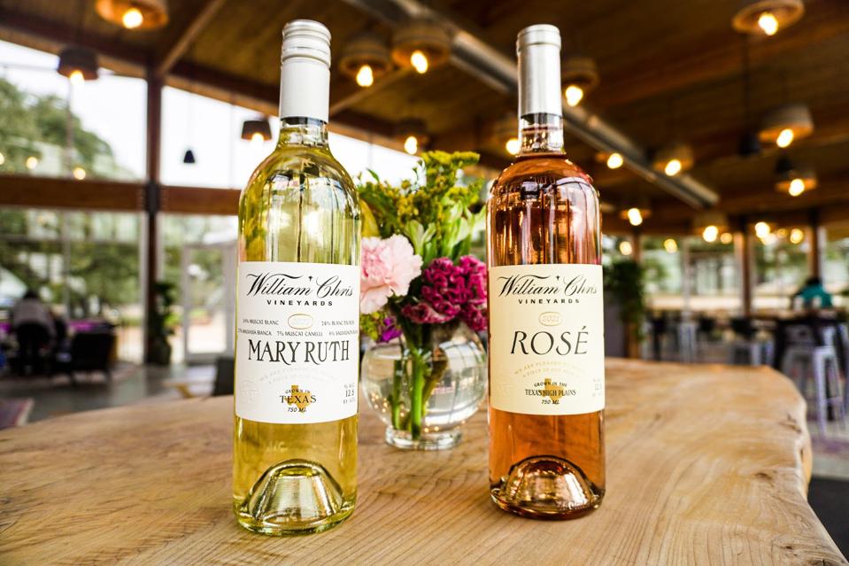 Bottles of William Chris white and rosé wines on a rustic wooden table