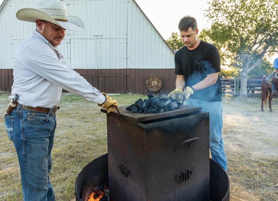 Cole Irvin of Old Forester working to create the mesquite charcoal chips used to filter the bourbon.