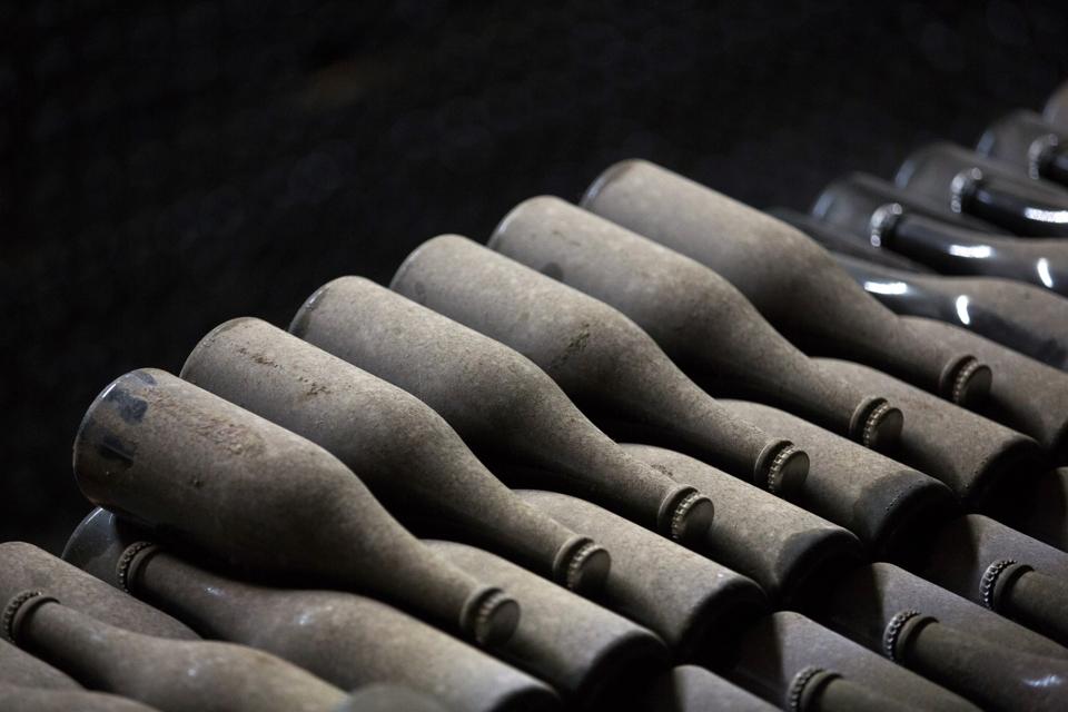 Champagne bottles sit covered in dust inside storage