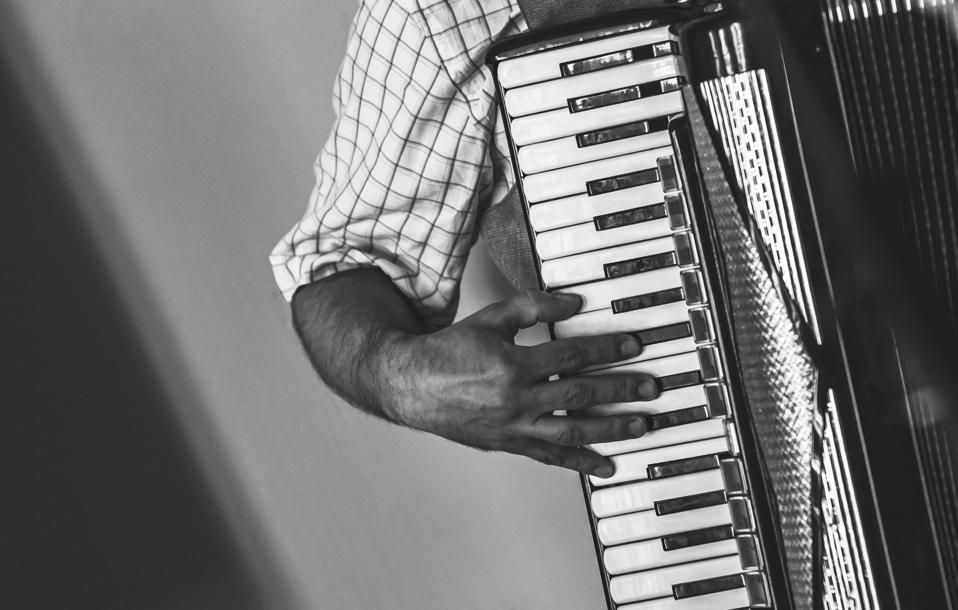 Accordionist plays accordion, black and white